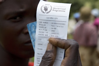 caption: A woman holds a voucher before receiving food aid in Mudzi, Zimbabwe, in February. On Friday, the United Nations World Food Programme received the 2020 Nobel Peace Prize.