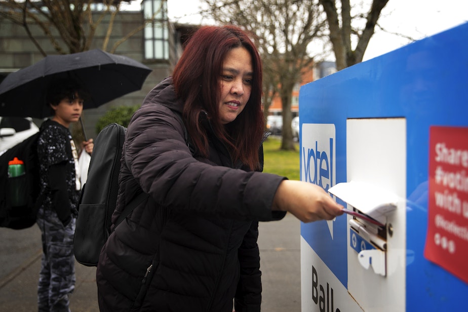 caption: Mutya Wetmore drops off her ballot ahead of the presidential primary on Monday, March 11, 2024, outside of the Beacon Hill Library in Seattle. 