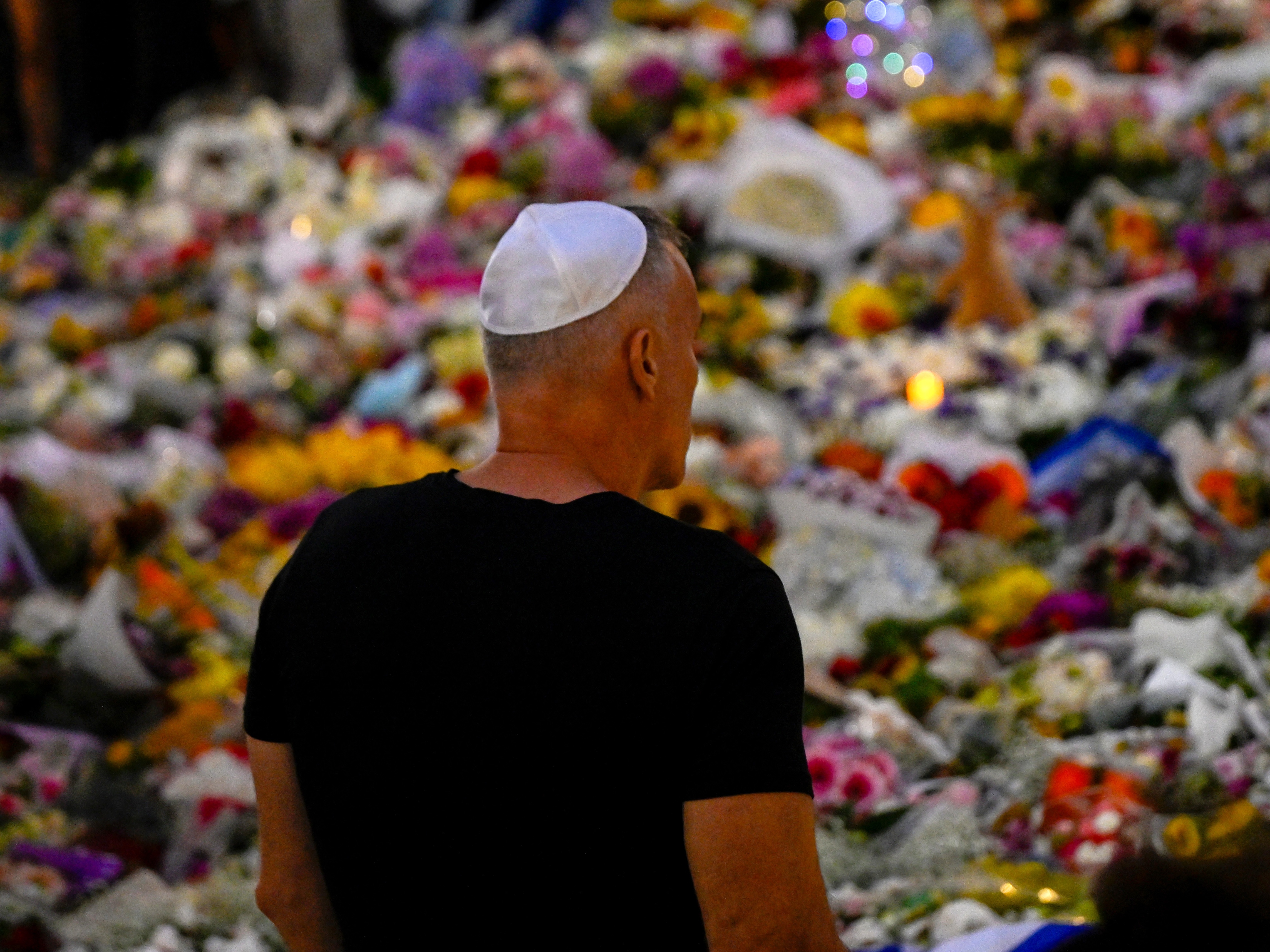 caption: Mourners gather at the Bondi Pavilion as people pay tribute to the victims of a mass shooting at Bondi Beach.