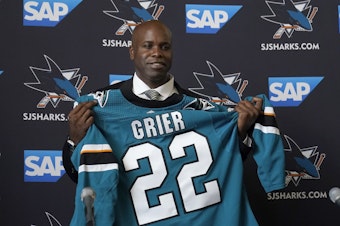 caption: Mike Grier poses for photos as he is introduced as the new general manager of the San Jose Sharks at a news conference in San Jose, Calif., Tuesday, July 5, 2022.