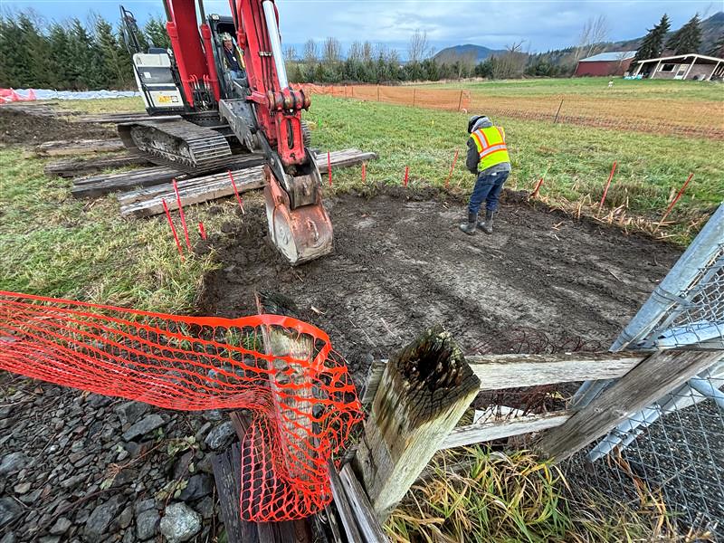 caption: Crews remove soil where the Olympic Pipeline spilled  gasoline into a Skagit County irrigation canal called Hill Ditch in December 2023.