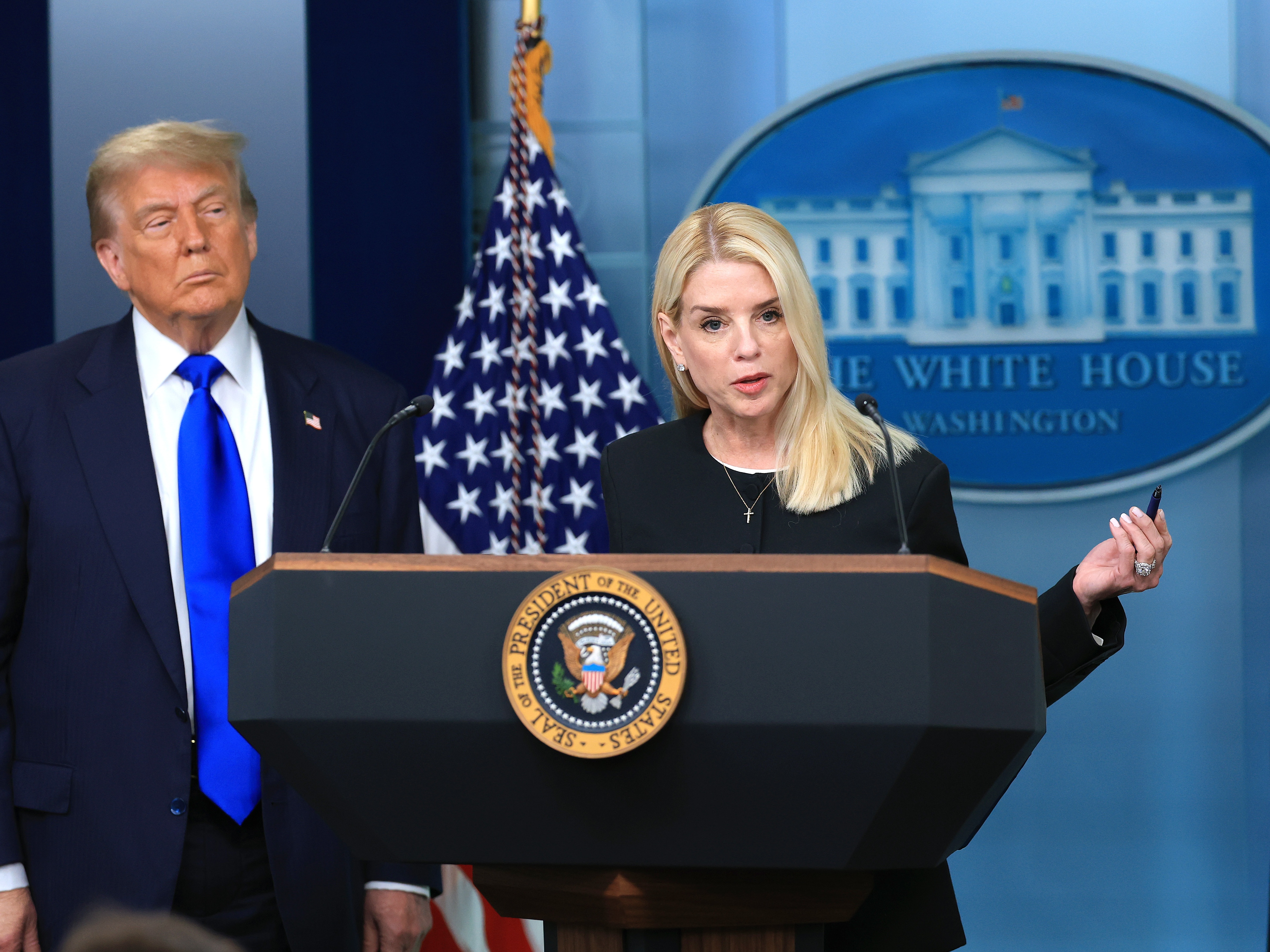 caption: Attorney General Pam Bondi speaks alongside President Trump in the briefing room at the White House in June 2025 in Washington, D.C.