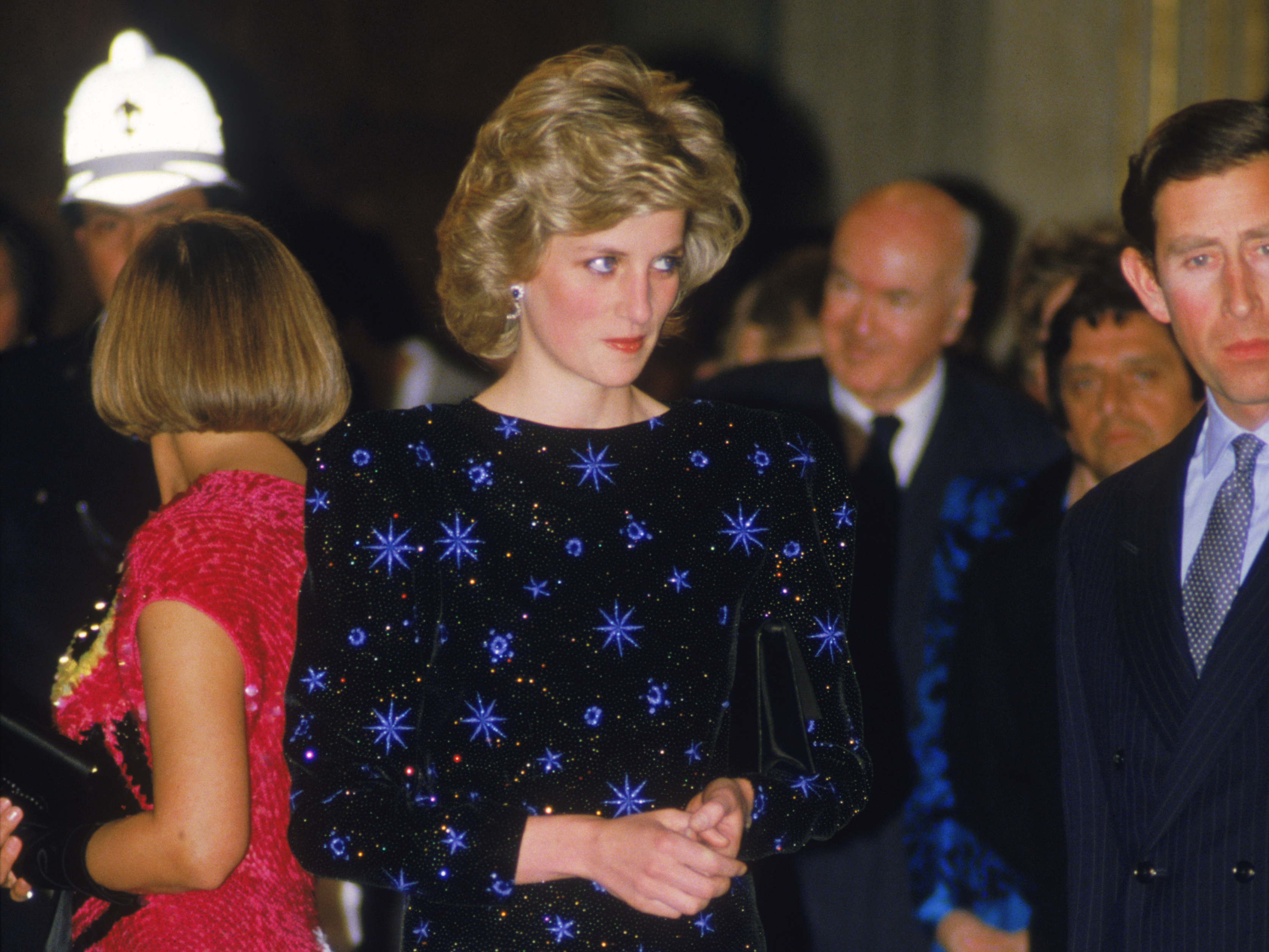 caption: The Prince and Princess of Wales attend a dinner held by the Mayor of Florence during a tour of Italy, April 1985. The Princess wears a dress by Jacques Azagury.