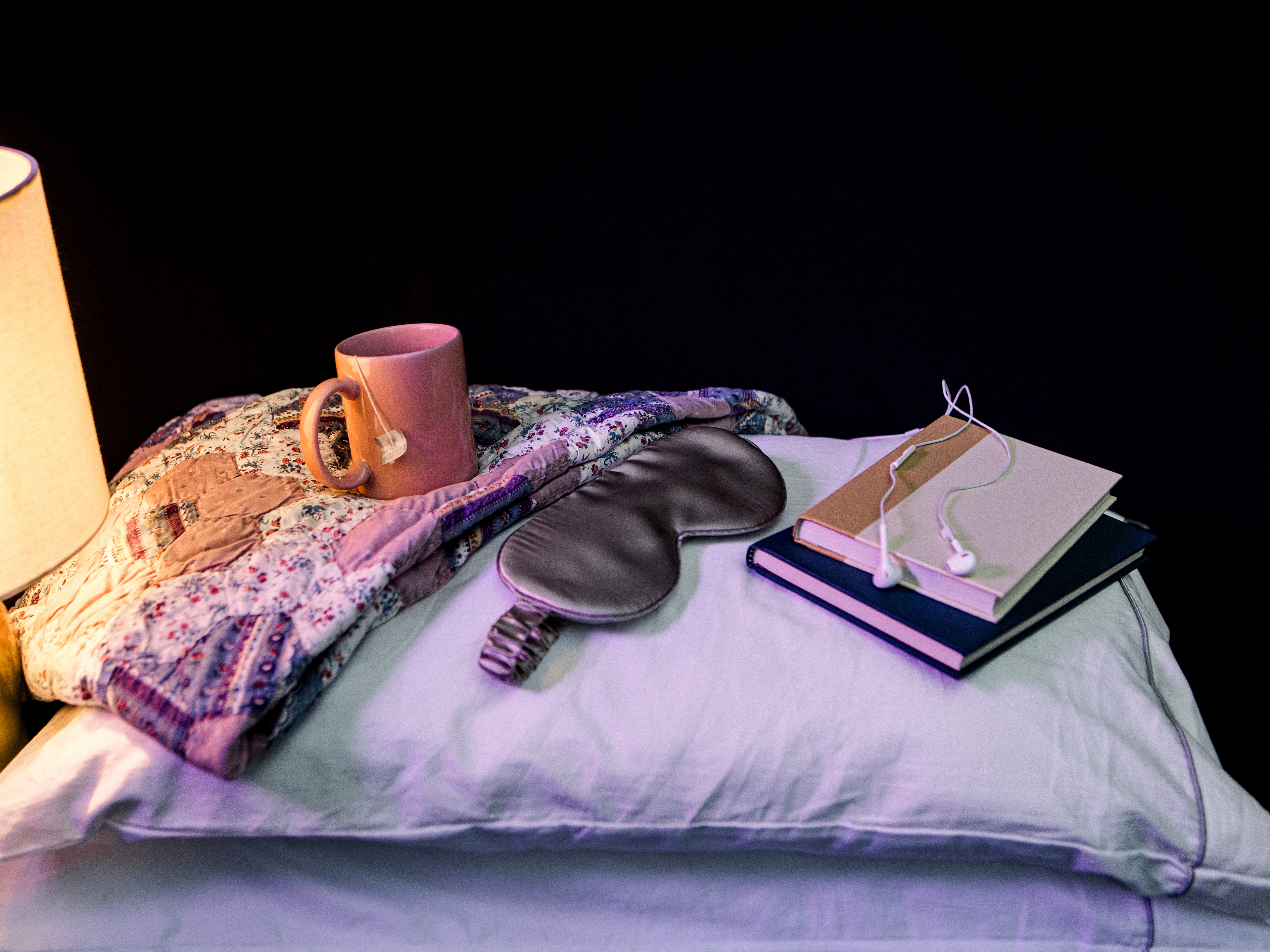 caption: A calming bedtime routine can help tell our bodies it's time for bed. Dim the lights in the evening, pour yourself a relaxing cup of tea and keep a notebook nearby to jot down any stressors (and get them out of your head).