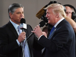 caption: Fox News host Sean Hannity interviews then-President Donald Trump in 2018 in Las Vegas.