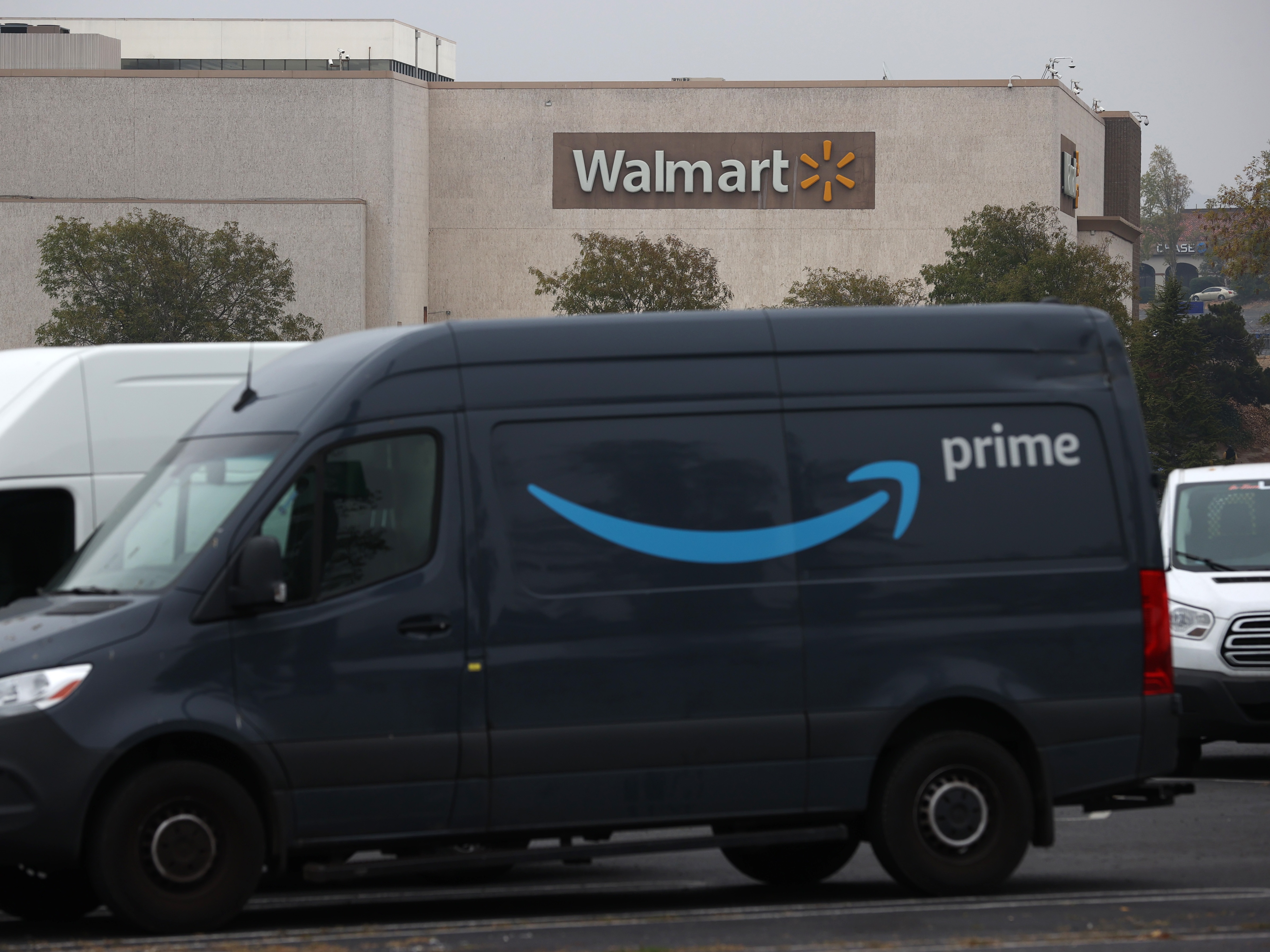 caption: An Amazon Prime delivery van sits parked near a Walmart store in California.