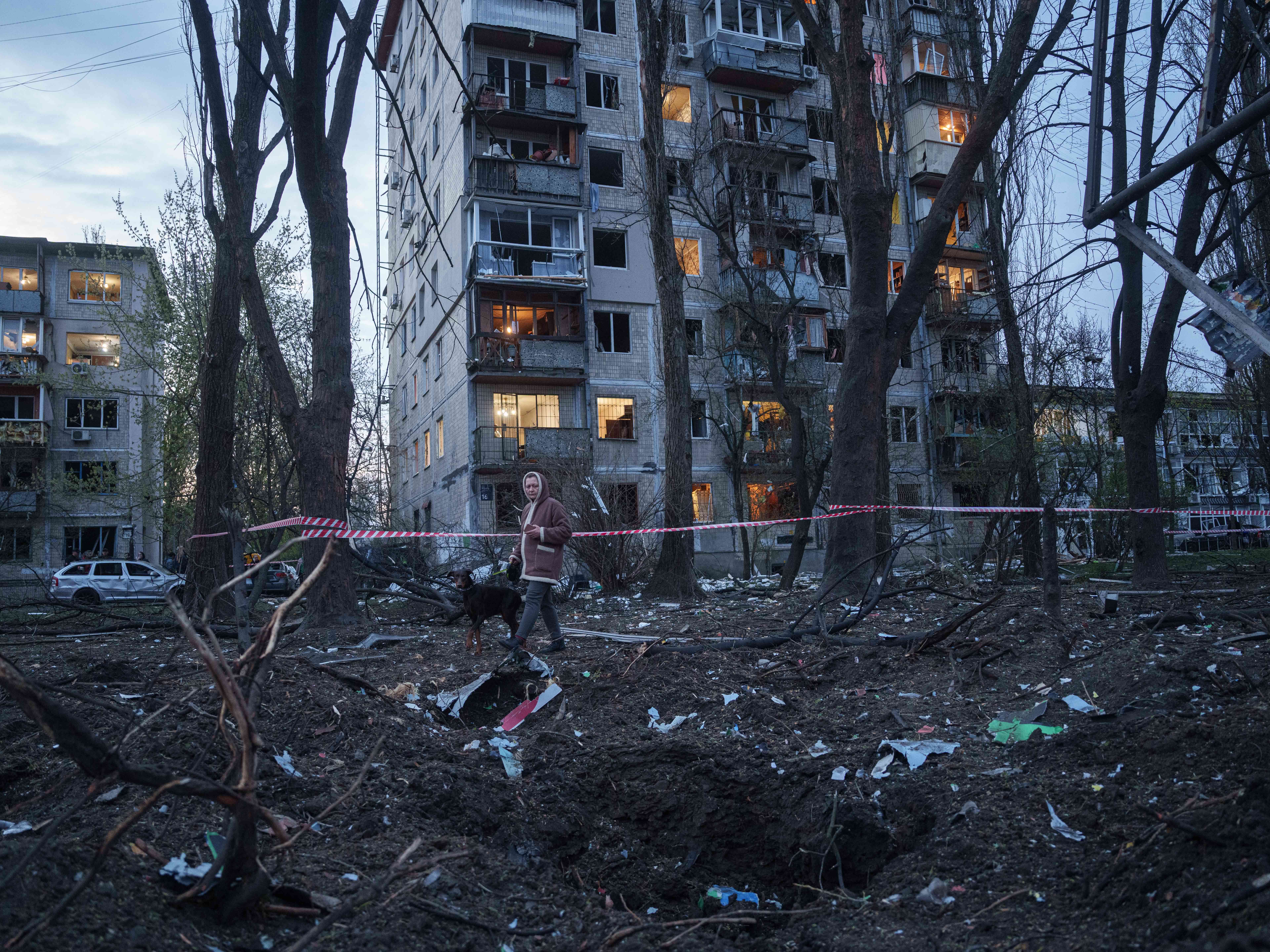 caption: A woman with a dog walks among the rubble of a house damaged after a Russian strike on residential area in Kyiv, Ukraine, on Thursday, April 16, 2026.