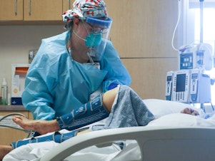 caption: A nurse cares for a coronavirus patient in the intensive care unit at El Centro Regional Medical Center in California's hard-hit Imperial County on July 28.