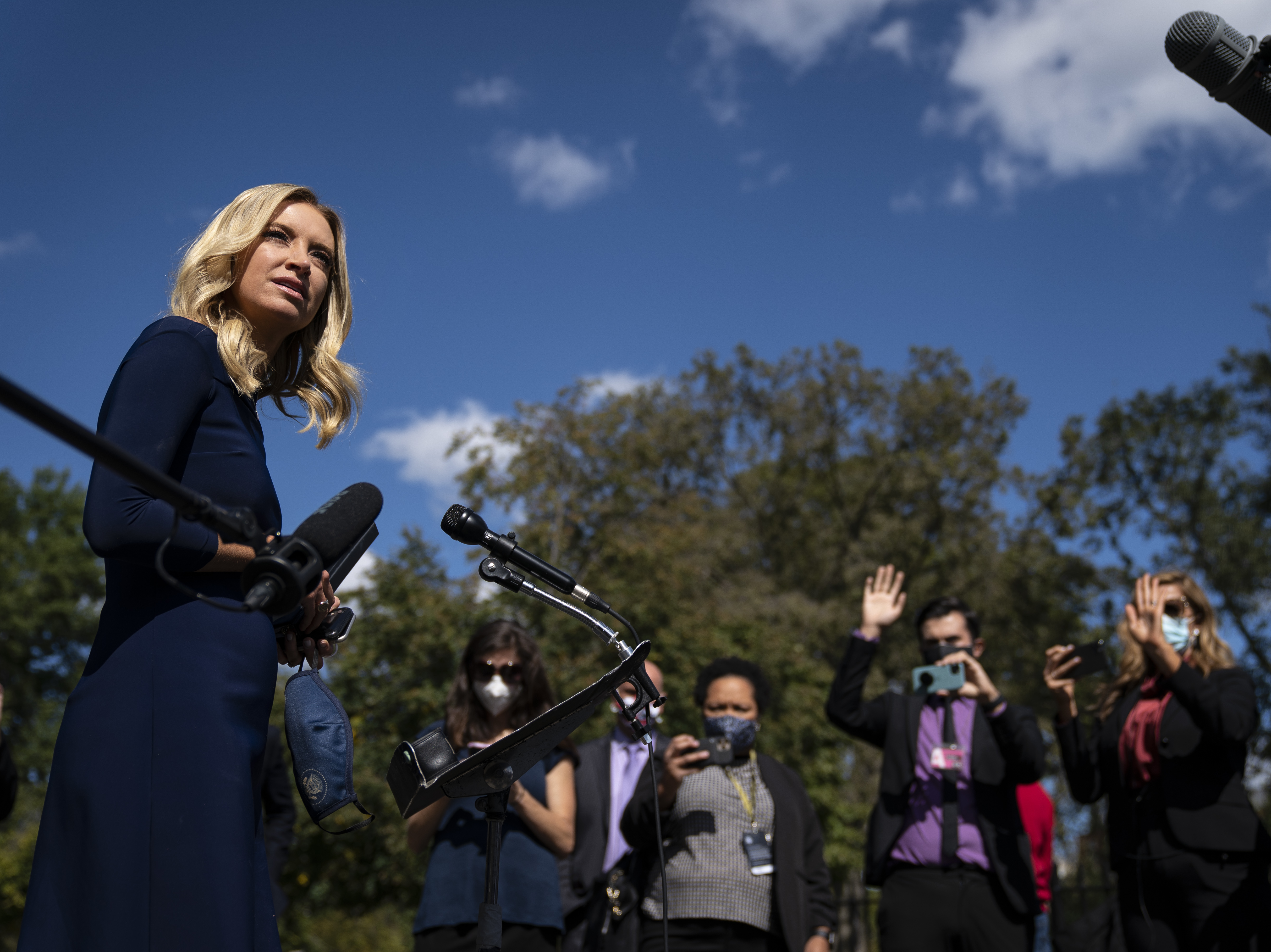 caption: White House press secretary Kayleigh McEnany talks to reporters last week outside the West Wing of the White House. She announced Monday that she tested positive for the coronavirus.