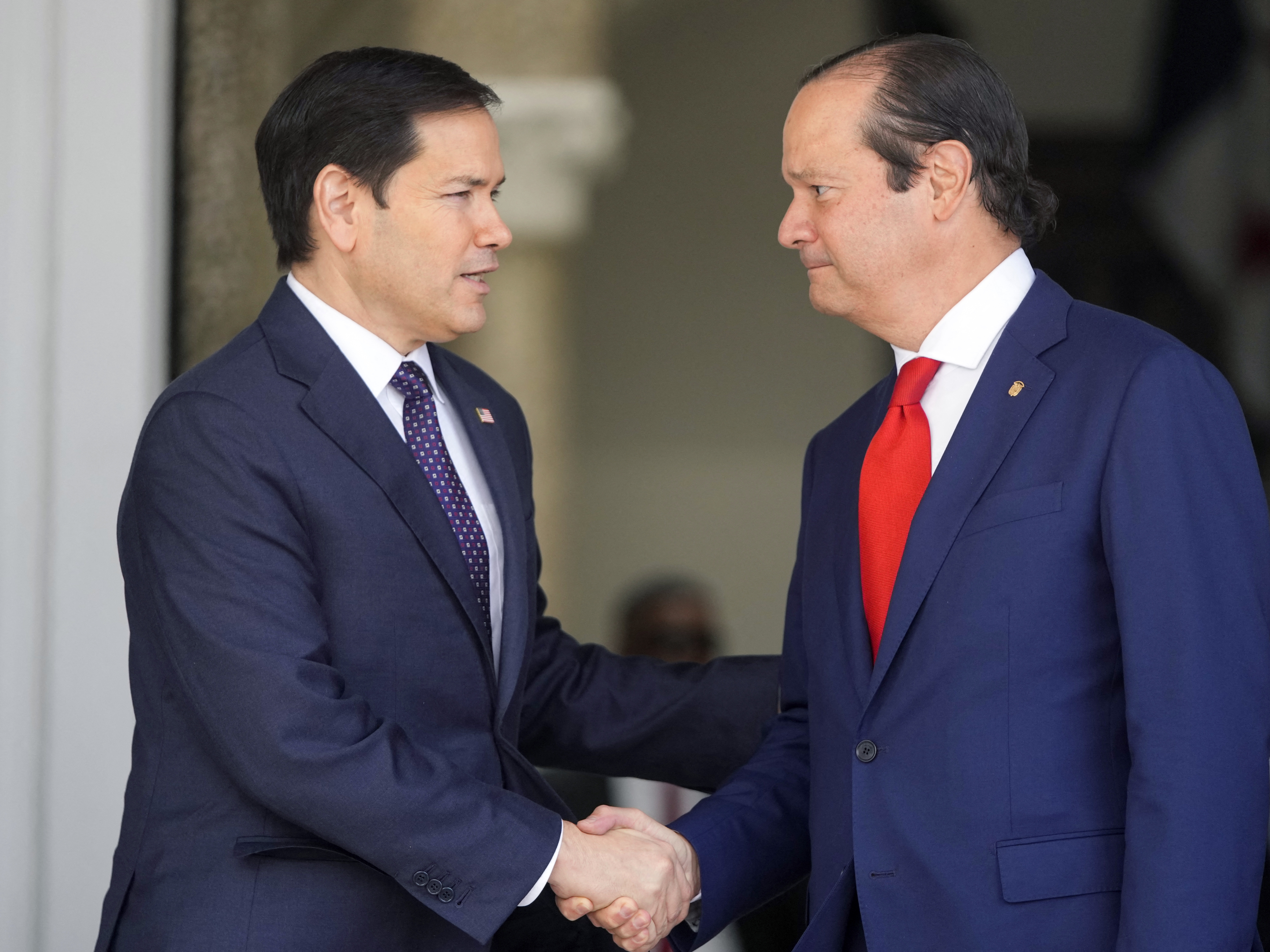 caption: Panama's Foreign Minister Javier Martinez-Acha (R) shakes hands with U.S. Secretary of State Marco Rubio while leaving a meeting at the presidential palace in Panama City, Panama, on Sunday.