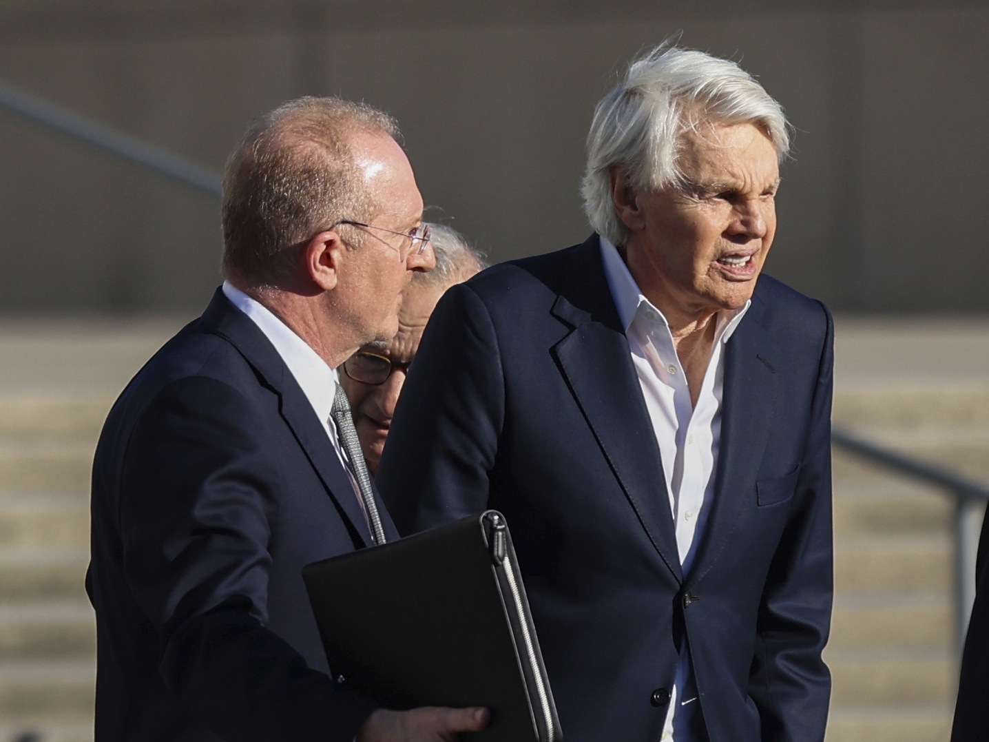 caption: Michael Jeffries (right), former CEO of Abercrombie &amp; Fitch, exits the federal courthouse after his arraignment on sex trafficking and interstate prostitution charges Oct. 25 in Central Islip, N.Y.