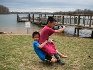 caption: Hayle tackles Henry during a game of football Black Hill Regional Park in Boyds, Md., on April 7, 2019.
