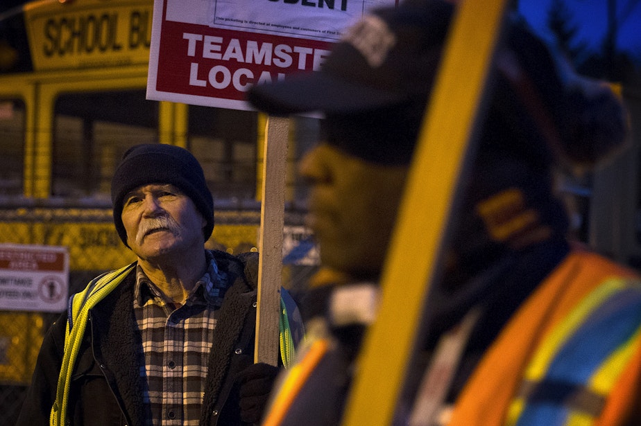 caption: Mike Browning, left, protests with other members of Teamsters Local 174 on Thursday, Feb. 1, 2018, outside of the First Student bus lot on Lake City Way Northeast in Seattle.