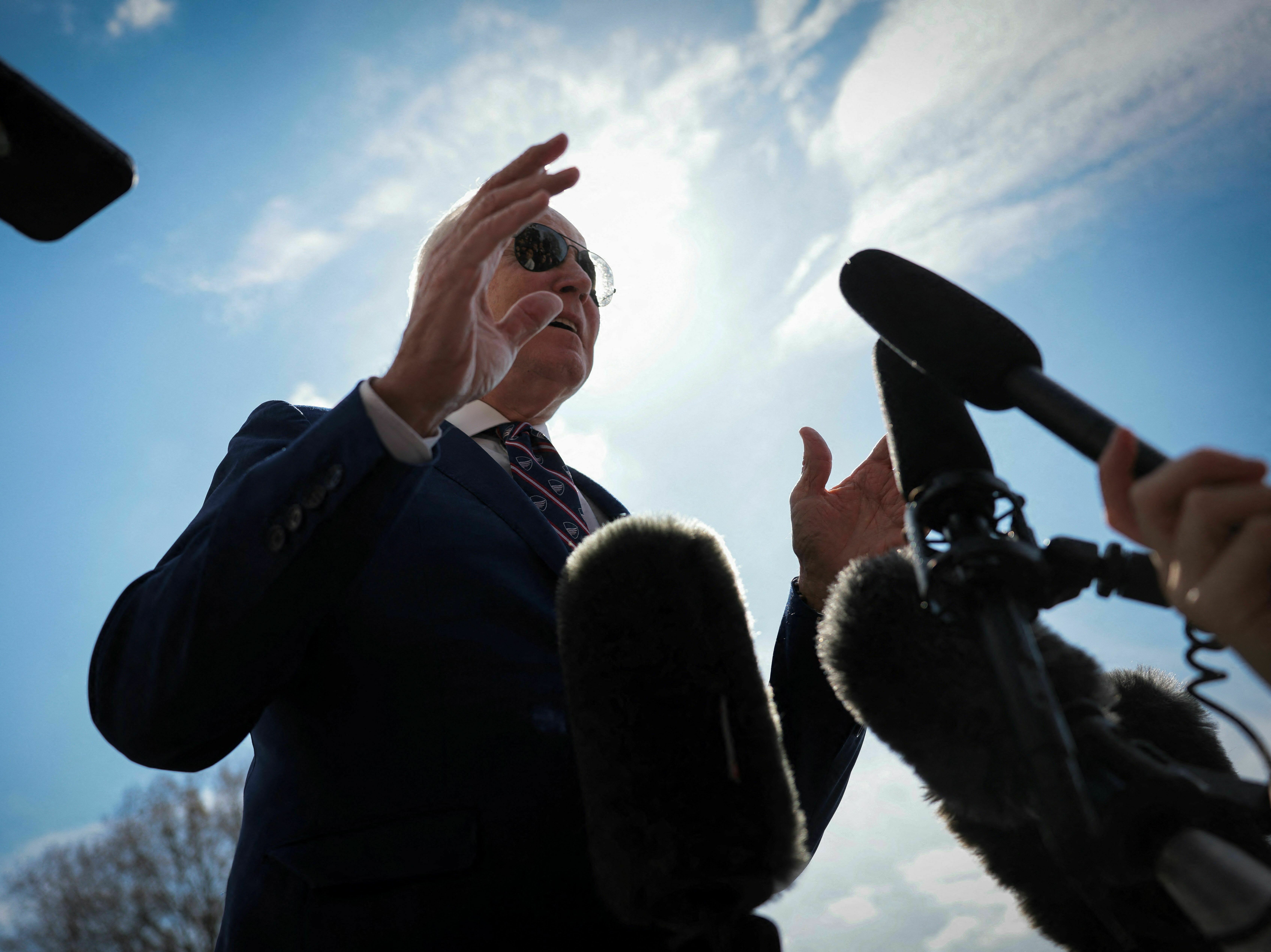 caption: President Biden talks to the press on the South Lawn of the White House before boarding Marine One on March 28 for a trip to Durham, N.C.