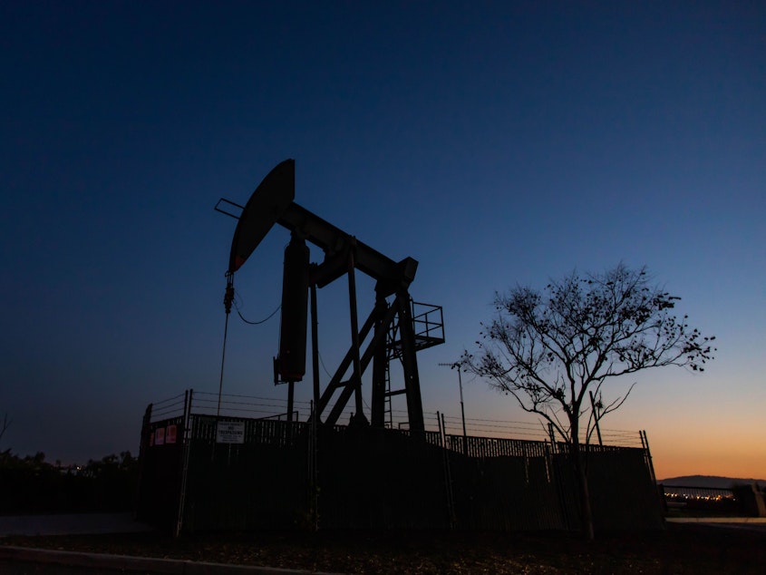 caption: An oil pumpjack operates at dusk Willow Springs Park in Long Beach, Calif. Producers have kept pumping, even if they're not making money, partly because wells — once shut down — can be difficult to get back up and running.