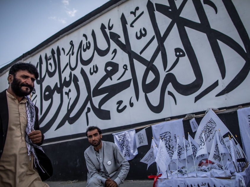 caption: A man sells Taliban flags imprinted with the Muslim creed in Kabul, Afghanistan, on Sept. 24.