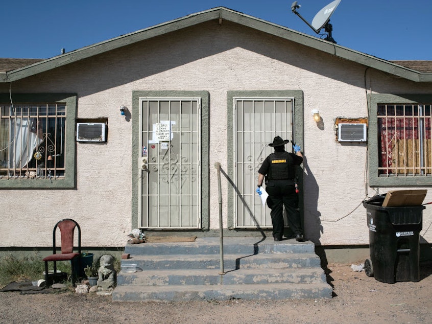 caption: Maricopa County constable Darlene Martinez knocks on a door before posting an eviction order on Oct. 1, 2020, in Phoenix. An extended eviction moratorium ordered by the Centers for Disease Control and Prevention is being challenged in court.