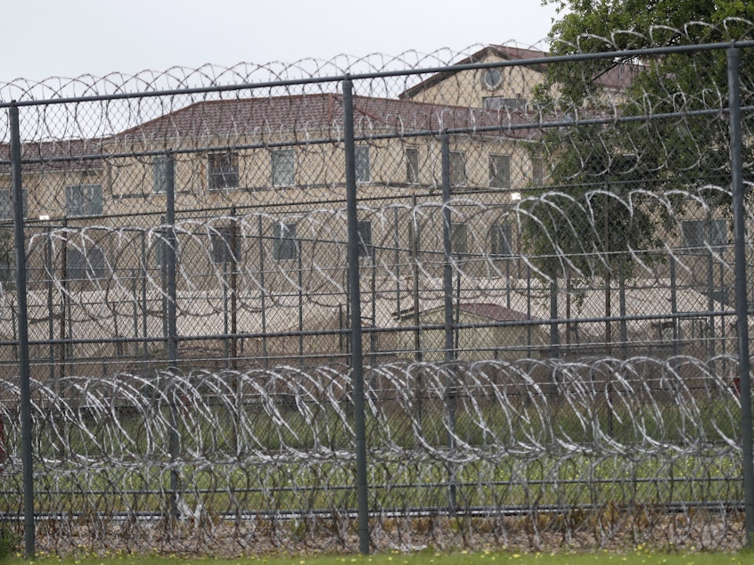 caption: Tents are seen behind wire fences near buildings of the Federal Medical Center prison in Fort Worth, Texas, on May 16, 2020. Hundreds of inmates inside the facility have tested positive for COVID-19 and several inmates have died.