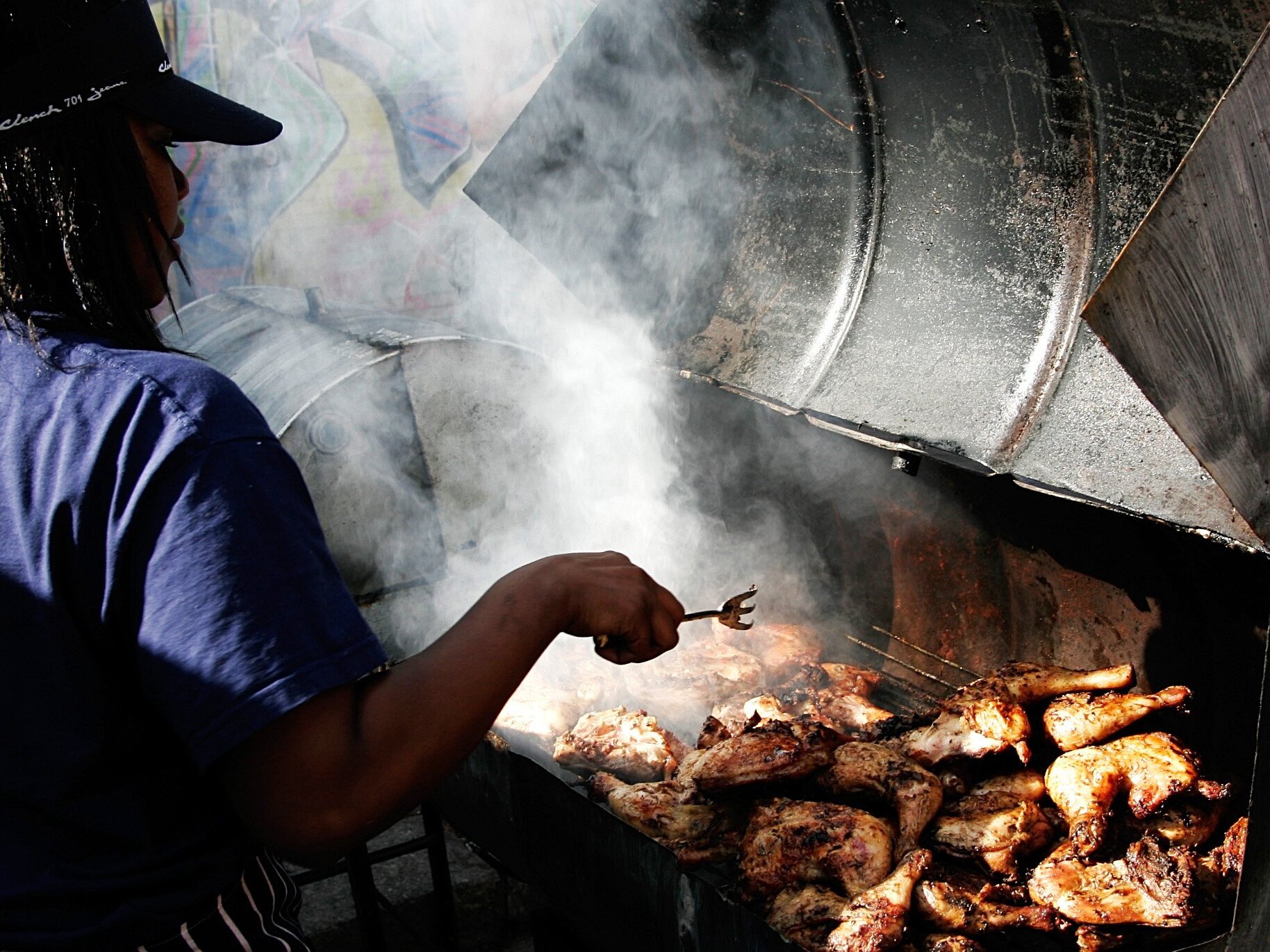 caption: Jamaican Jerk Chicken cooks on the charcoal grill during the Notting Hill Carnival in 2006 in London.