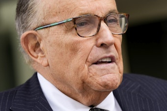caption: Rudy Giuliani speaks with reporters as he departs the federal courthouse, May 19, 2023, in Washington. 