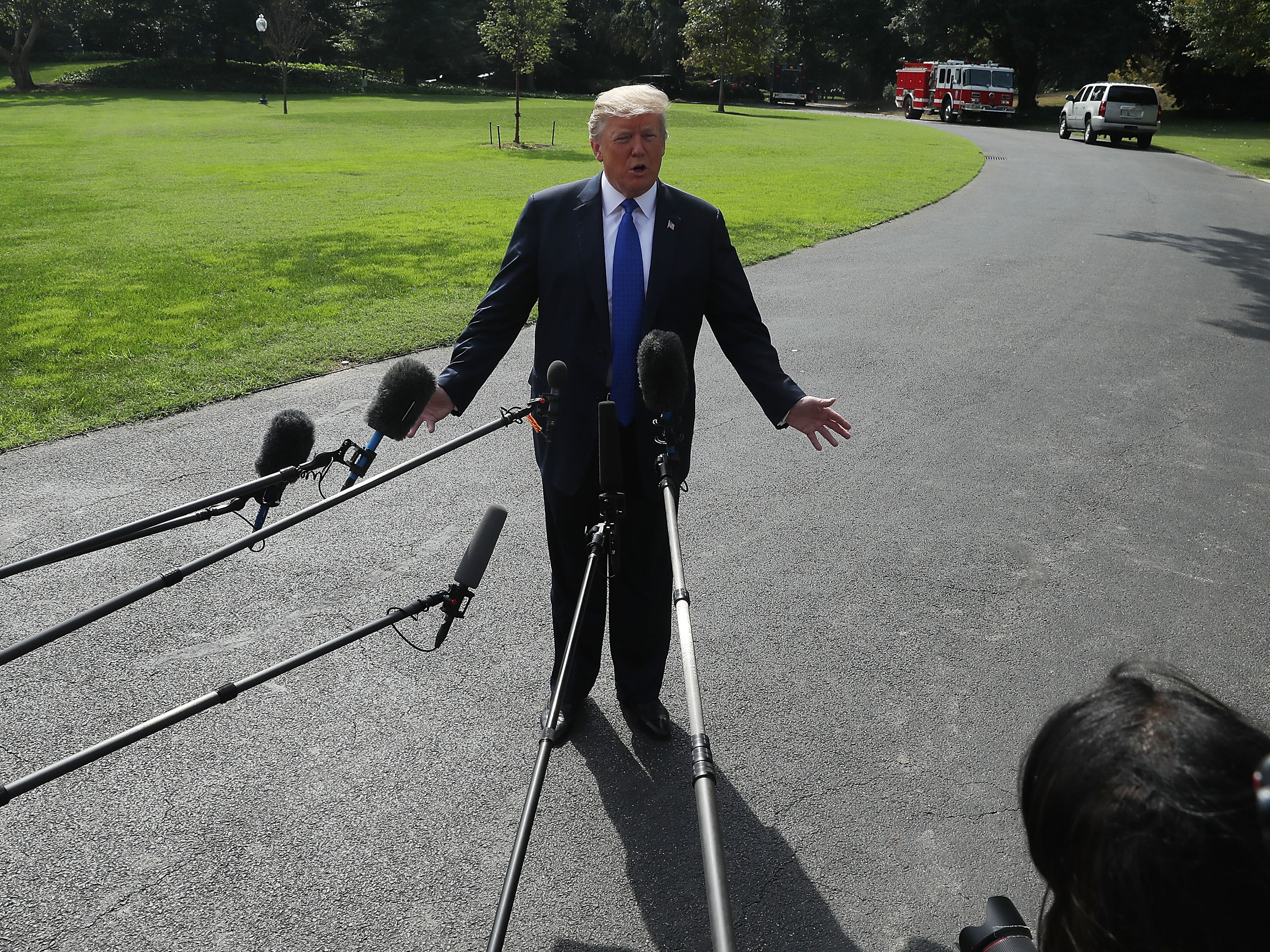 caption: President Donald Trump speaks to the media before departing from the White House en route to speak with electrical workers in Philadelphia, Penn.