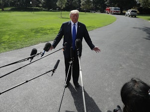 caption: President Donald Trump speaks to the media before departing from the White House en route to speak with electrical workers in Philadelphia, Penn.