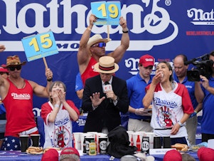 caption: Miki Sudo (right) and Mayoi Ebihara compete in the women's division of Nathan's Famous Fourth of July hot dog eating contest, Thursday, at Coney Island in the Brooklyn borough of New York. Sudo won by eating a record 51 hot dogs.