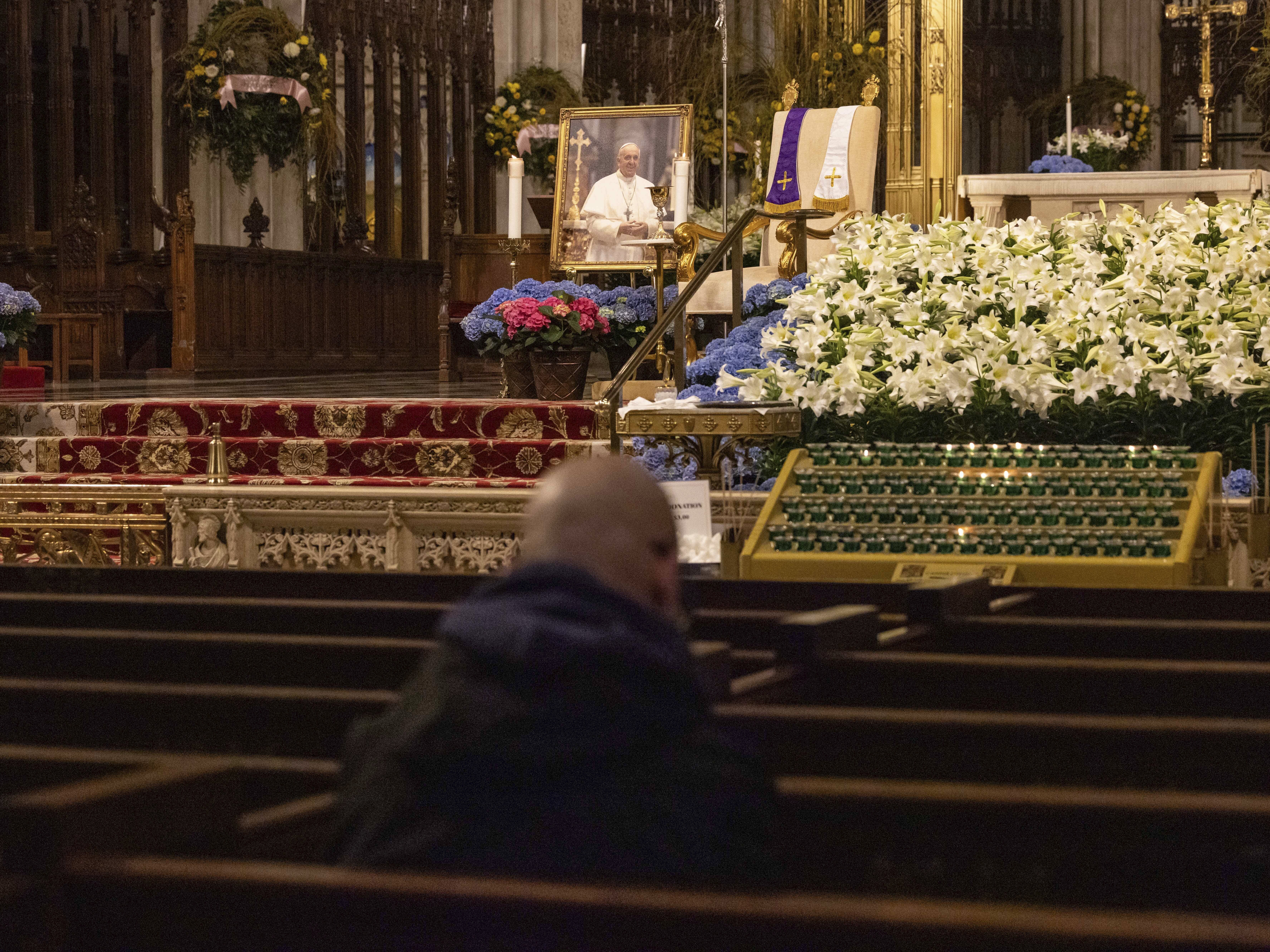 caption: A parishioner prays at St. Patrick's Cathedral, Monday, April 21, 2025, in New York.