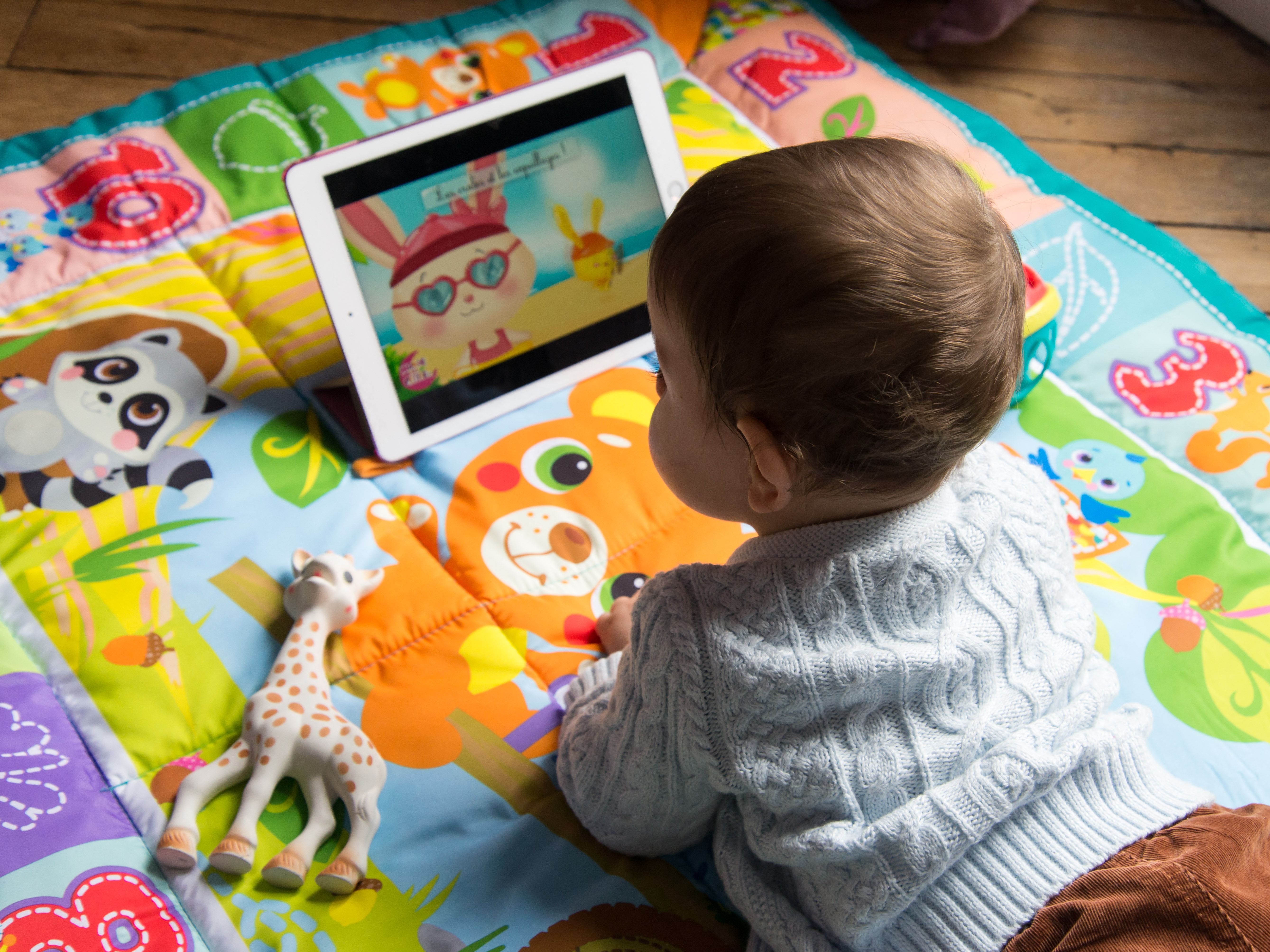 caption: An 8-month-old baby watches a cartoon on a tablet. A survey by Common Sense Media found that 80% of parents are worried about their children spending too much time on screens.