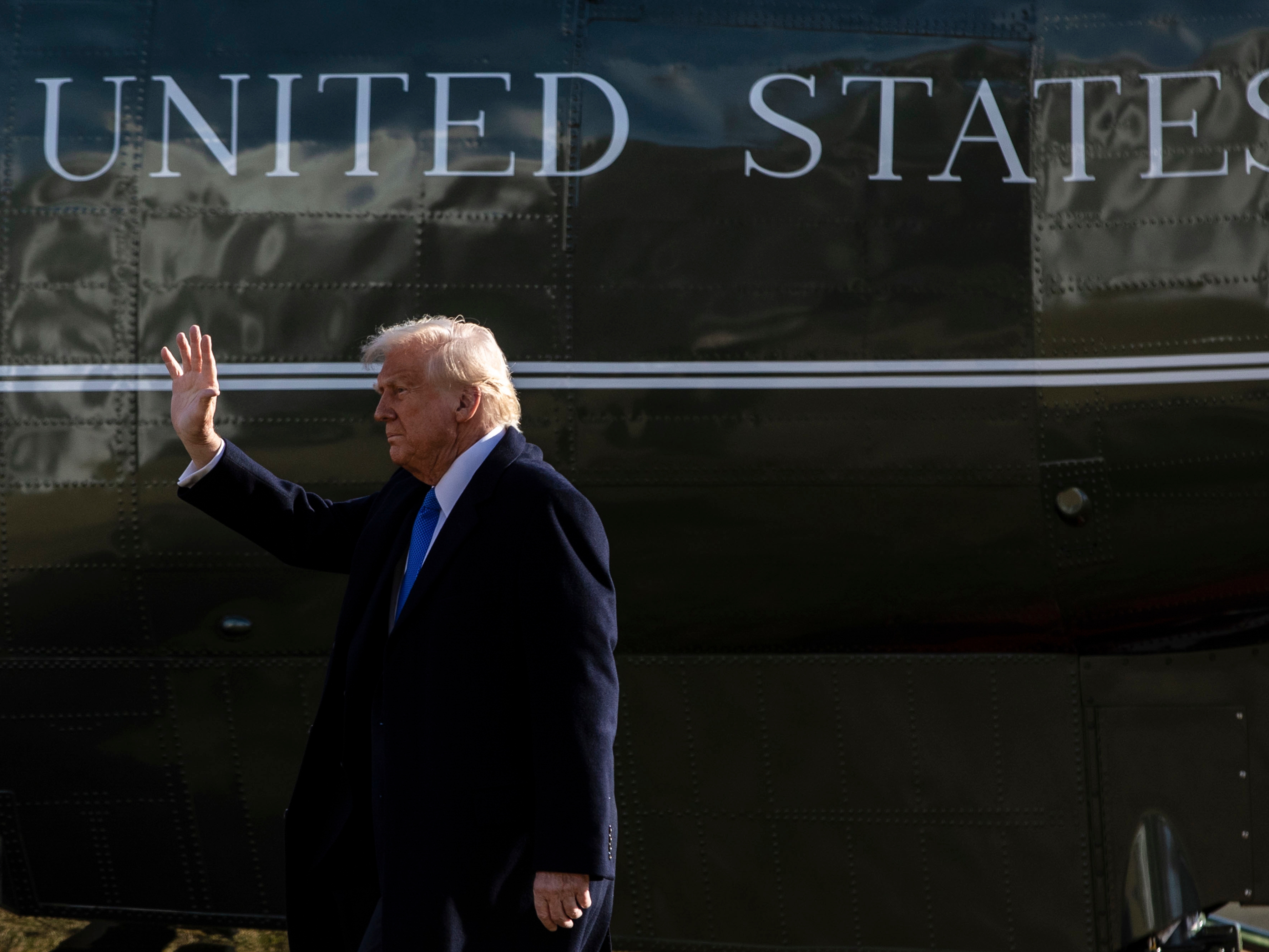caption: President Trump walks on the South Lawn of the White House before boarding Marine One in Washington, D.C., on Friday.