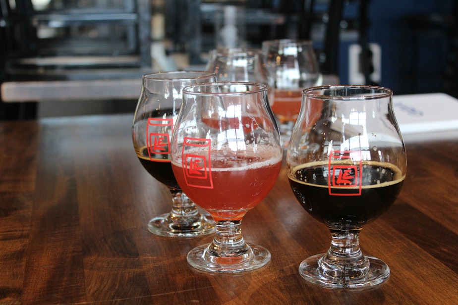 caption: Lucky Envelope's Dragonfruit Wheat Beer (pink in color) and Double Happiness Imperial Stout in the brewery's taproom glasses.