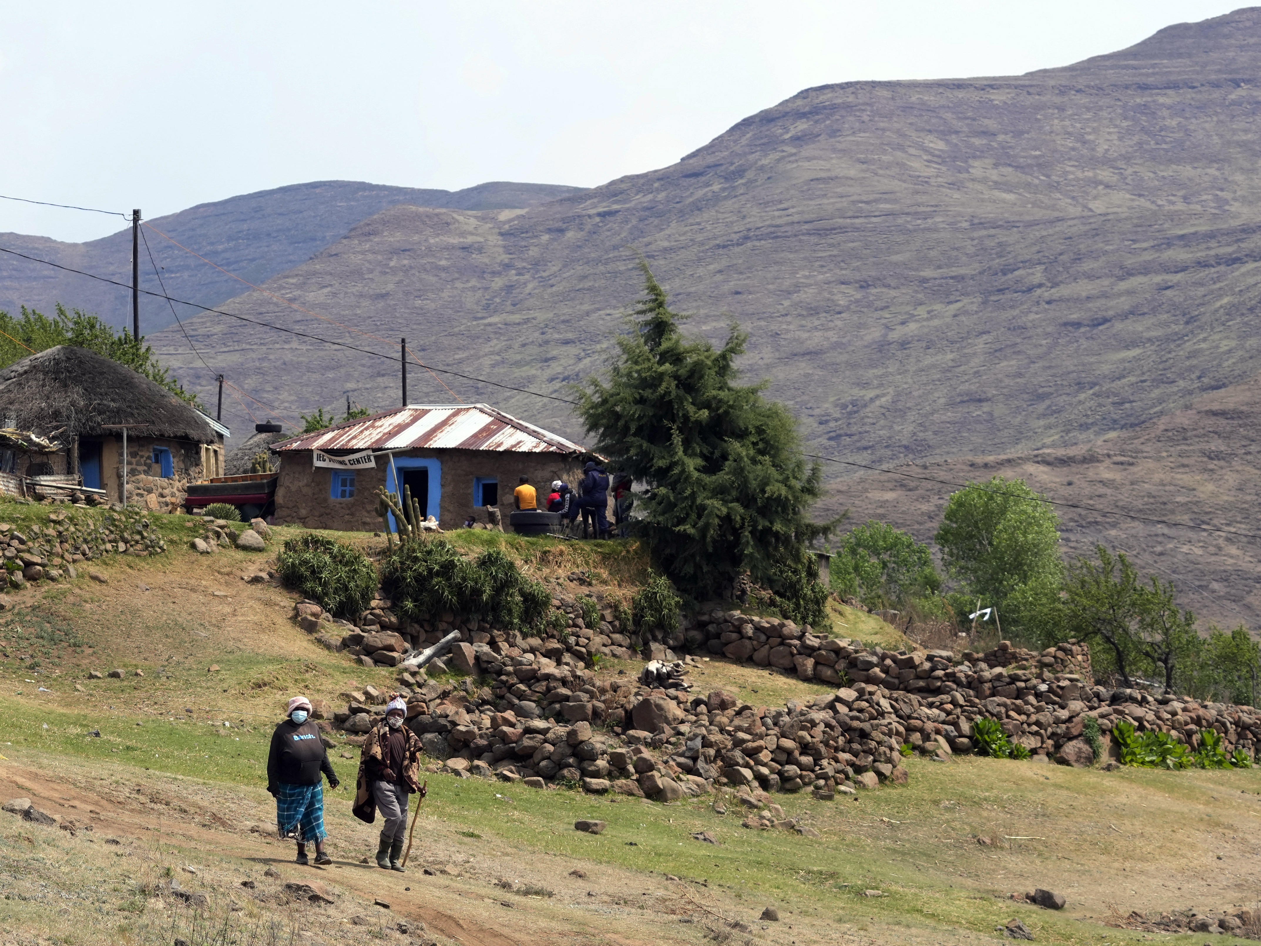 caption: Women leave the poling station after casting their vote in Thaba-Tseka district, Lesotho, on Oct. 7, 2022.