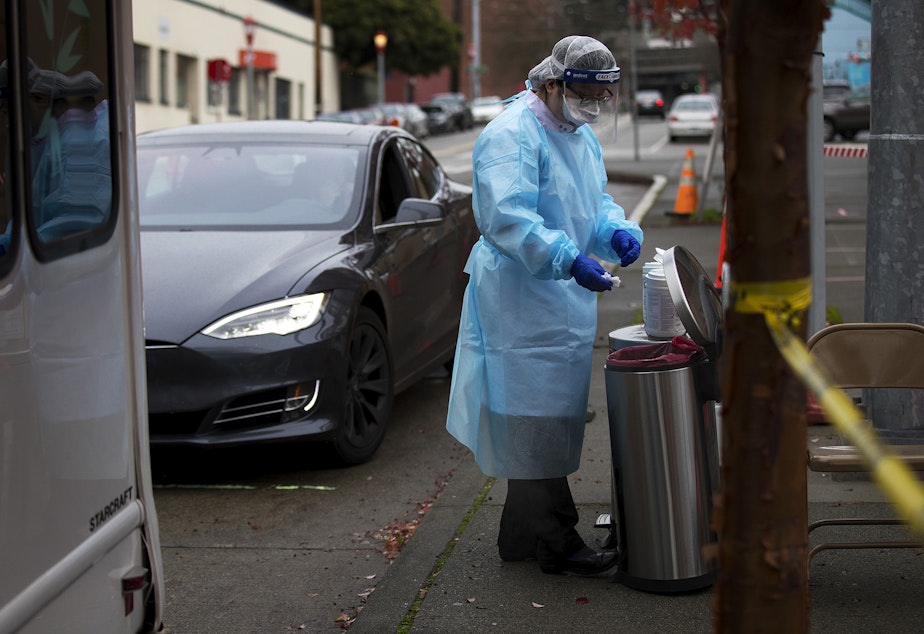 caption: Registered nurse Tina Nguyen uses a disinfectant wipe after administering a Covid-19 test on Friday, November 20, 2020, at the International Community Health Services drive thru testing site on 8th Avenue South in Seattle's International District.