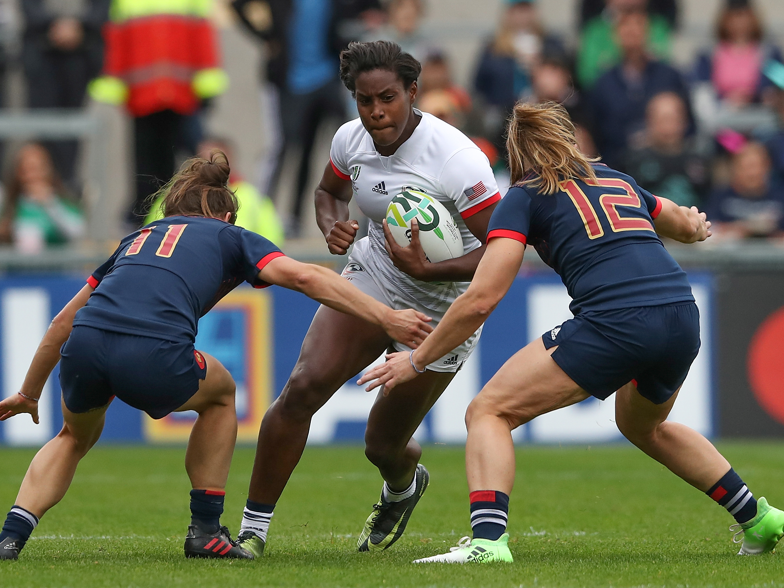 caption: Naya Tapper of the USA is tackled by Camille Grassineau (left) and Elodie Poublan of France during the 2017 Women's Rugby World Cup third-place match in Belfast. The U.S. will host the women's tournament for the first time in 2033.