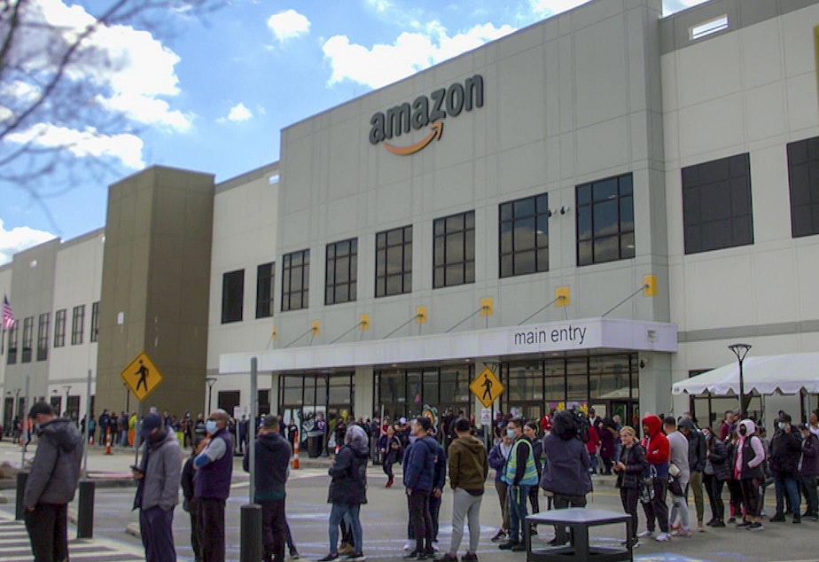 caption: Workers line up to vote on unionization at Amazon's warehouse in Staten Island on March 25.