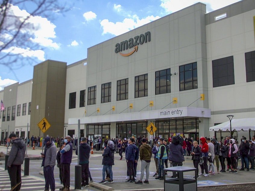 caption: Workers line up to vote on unionization at Amazon's warehouse in Staten Island on March 25.