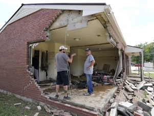 caption: Brian Mitchell, right, looks through the damaged home of his mother-in-law along with family friend Chris Hoover, left, Sunday, Aug. 22, 2021, in Waverly, Tenn. Heavy rains caused flooding Saturday in Middle Tennessee and have resulted in multiple deaths as homes and rural roads were washed away.