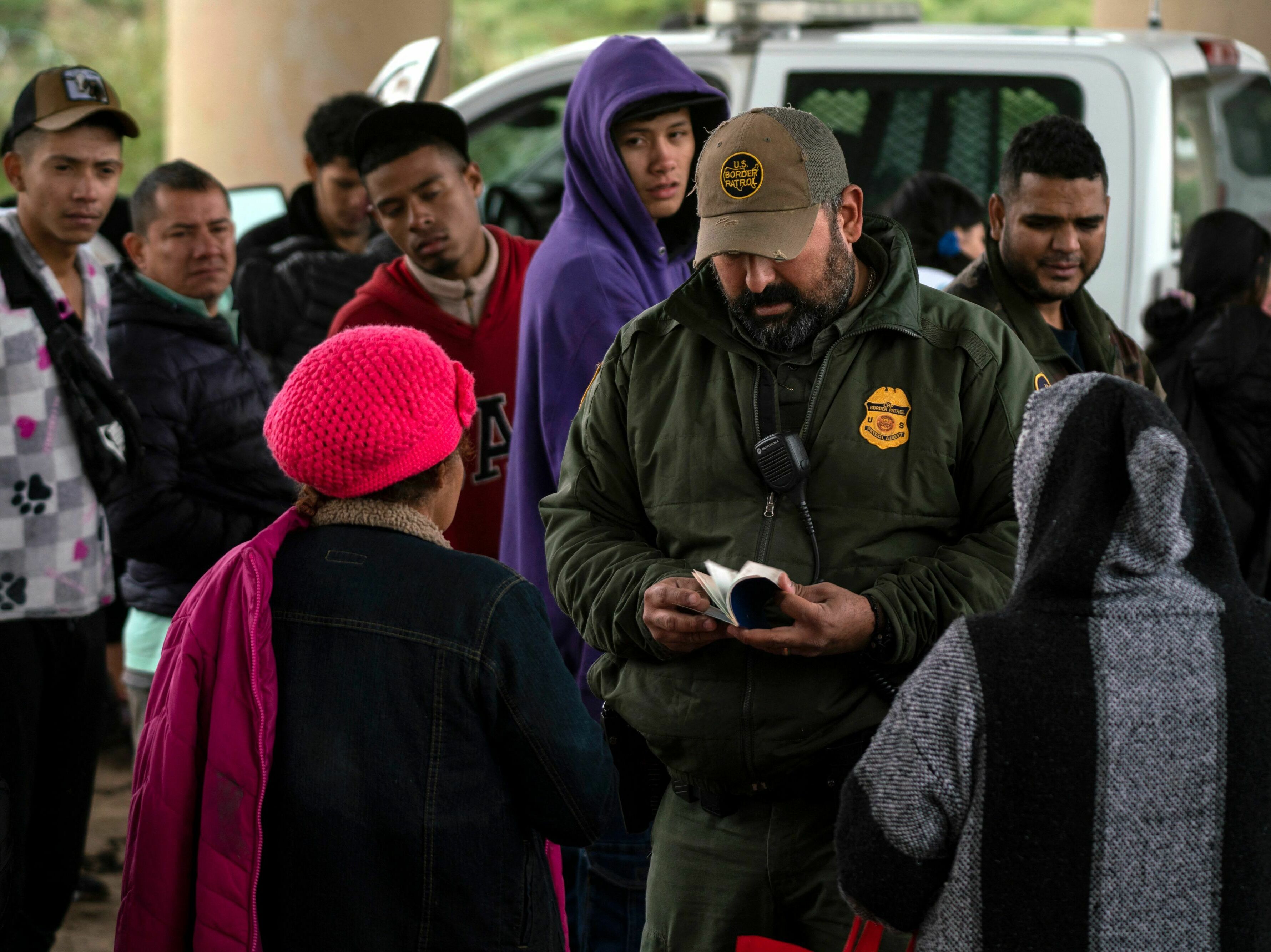 caption: A Border Patrol agent checks an asylum seeker's passport after she turned herself in, in Eagle Pass, Texas, on Dec. 19.