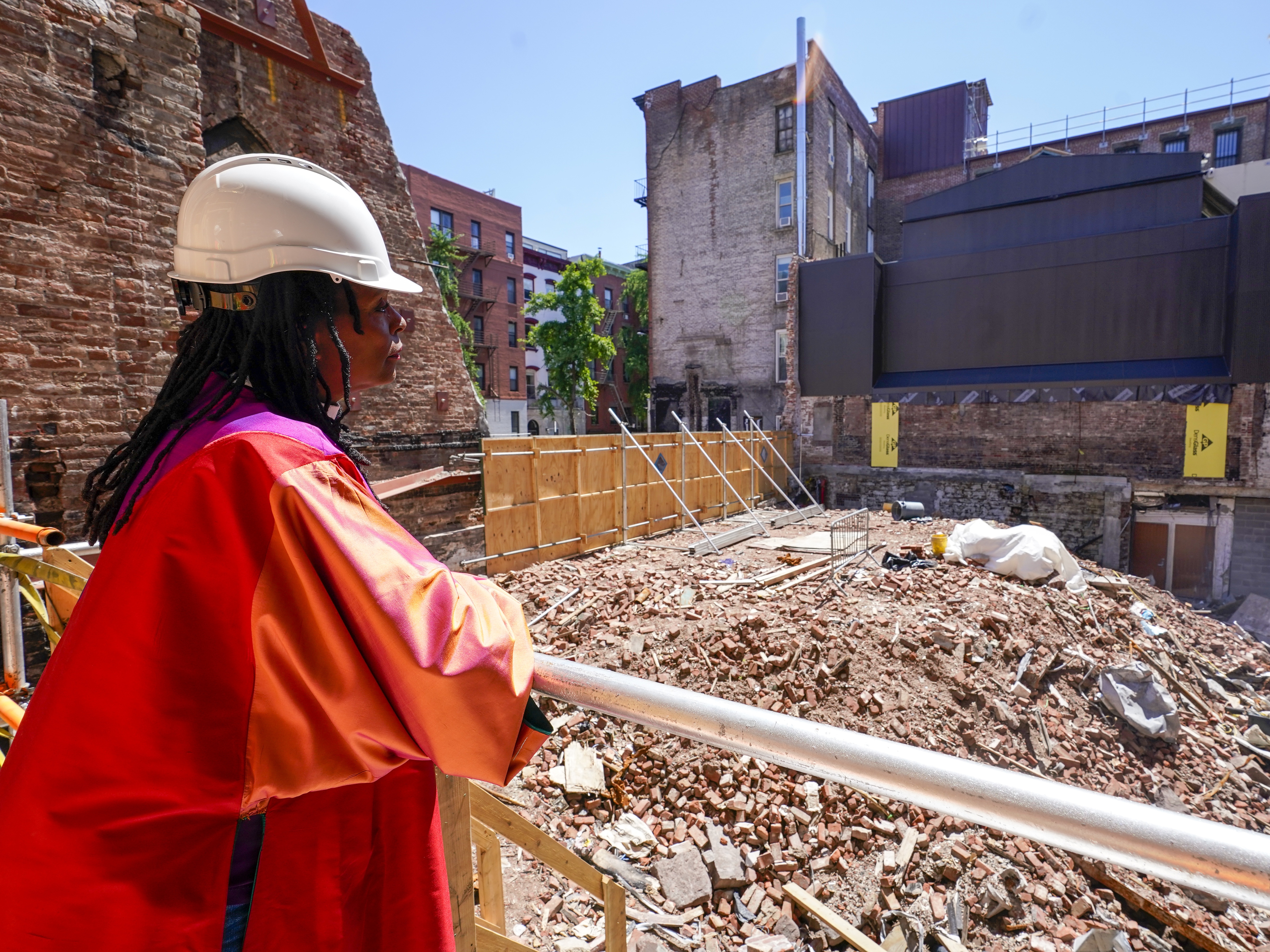 caption: Senior Pastor Rev. Jacqueline J. Lewis poses overlooking the rubble of Middle Collegiate Church in New York's East Village on June 16, 2021, after the historic building was destroyed by a six-alarm fire in December 2020. Lewis recently spoke with NPR's <em>Morning Edition</em> about marking Christmas this year with the church's first in-person Christmas Eve service since the fire,