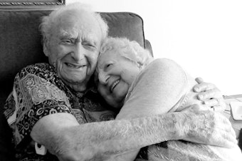 caption: Joe Newman, 107, hugs his fiancée, Anita Sampson, who recently celebrated her 100th birthday with a party over Zoom.