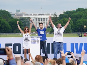 caption: Manny Oliver, Patricia Oliver and David Hogg speak during a March for Our Lives rally in June 2022.