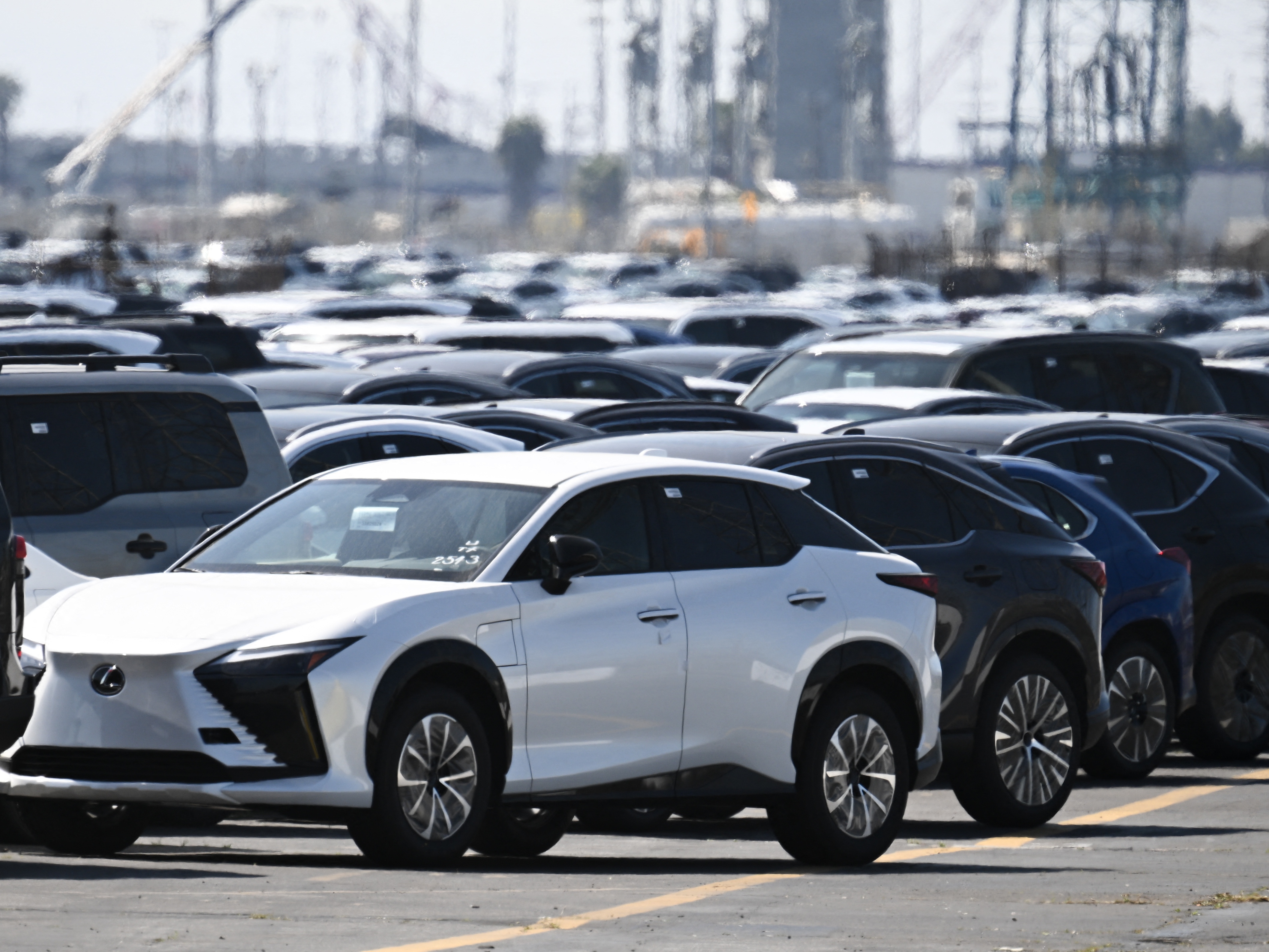 caption: Toyota and Lexus cars unloaded from ships sit parked at the Toyota Logistics Services Inc. automotive processing terminal at the Port of Long Beach in Long Beach, Calif., on April 10.