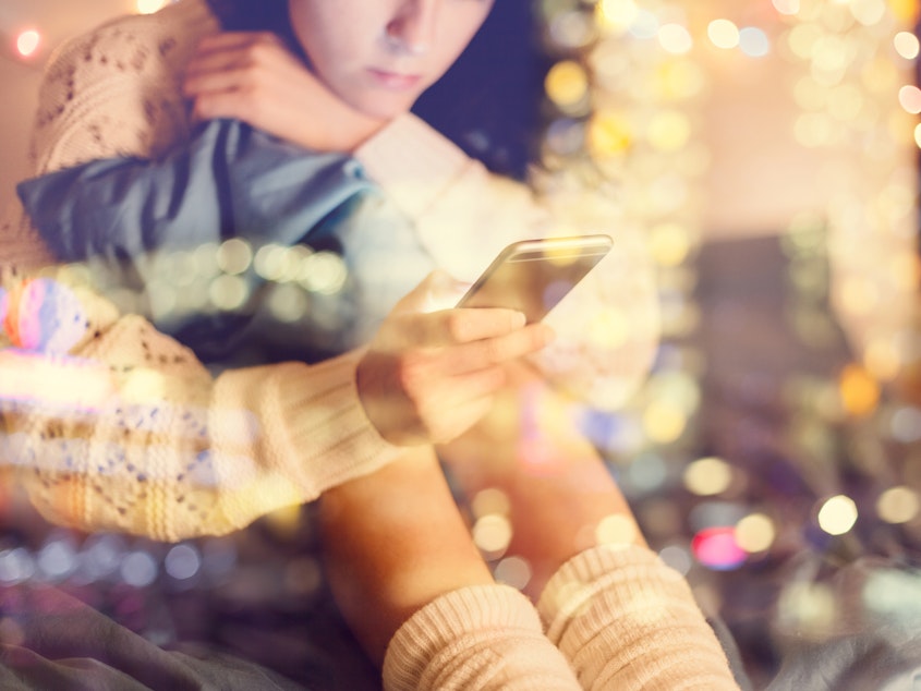 caption: Girl texting on smartphone at home