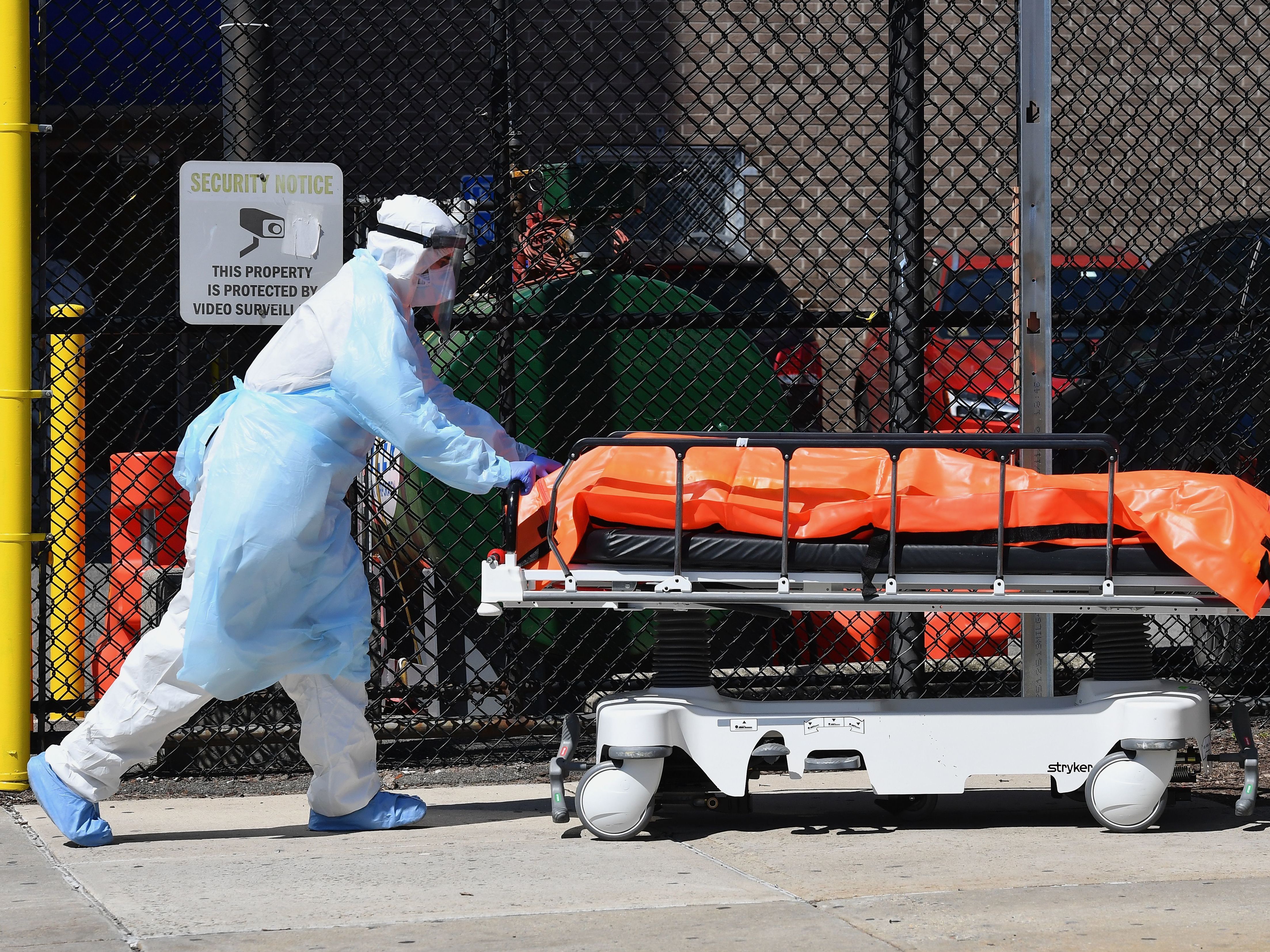 caption: Medical staff move bodies from the Wyckoff Heights Medical Center in Brooklyn, N.Y., Thursday to a refrigerated truck.