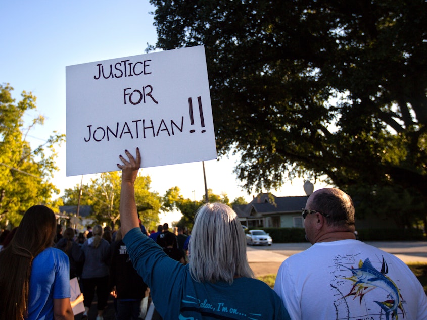 caption: People gather for a march, rally and candlelight vigil in honor Jonathan Price in Wolfe City, Texas, on Monday. Wolfe City police officer Shaun Lucas has been charged in relation to the fatal shooting.