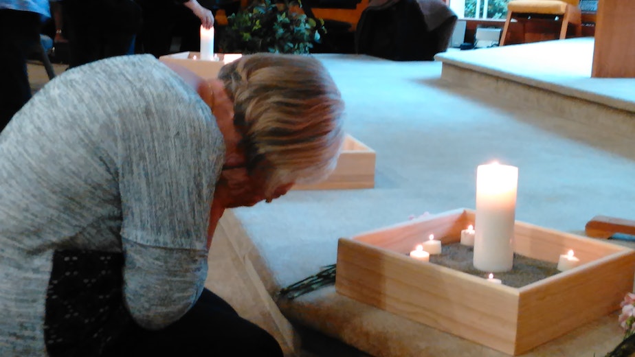 caption: Community members light candles for the victims of the Cascade mall shooting