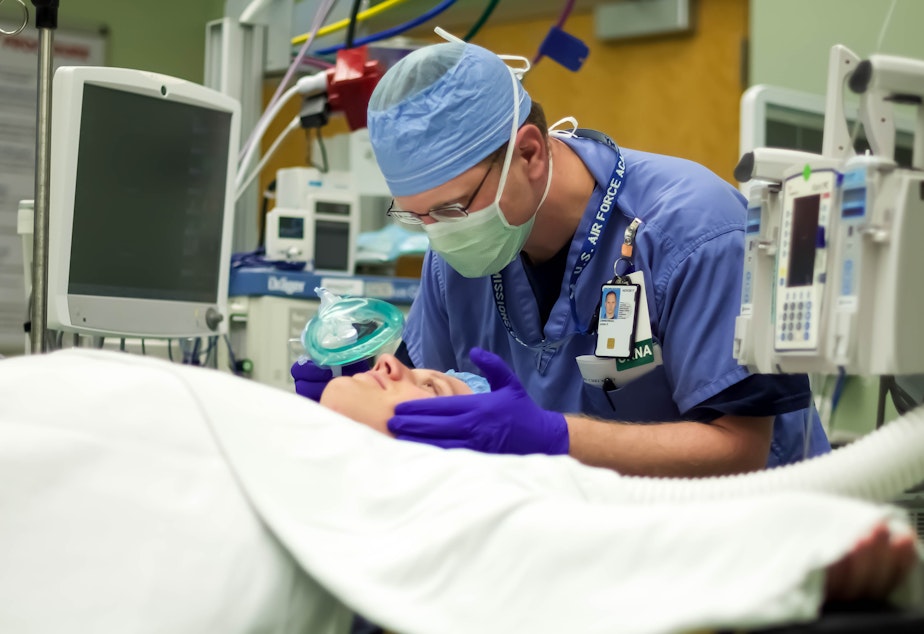 caption: John Zimmerman, a nurse anesthetist for the Veterans Administration in Minneapolis, leans over a patient. Under a new rule, some nurse practicioners are allowed to work independently rather than under a physician's close supervision.