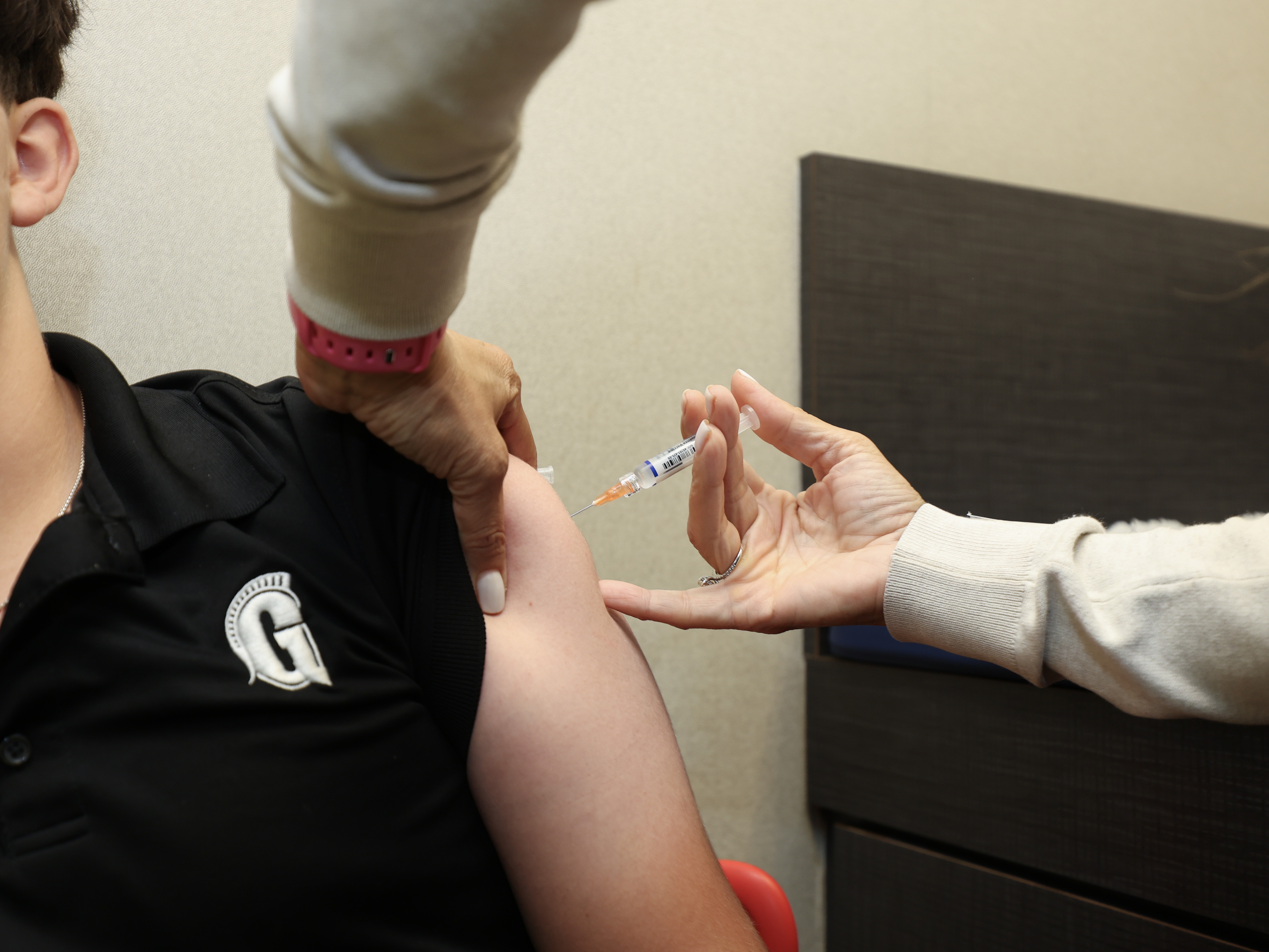 caption: A child receives an immunization at a Florida pediatrician's office in Sept. 2025.