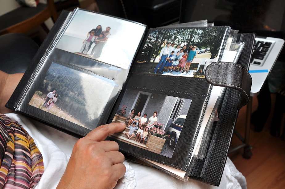 caption: Milagros Ortiz holds a family photo album at her home in Vancouver, British Columbia. She left her home country, Nicaragua, at age eighteen.