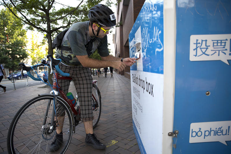 caption: A voter returns a ballot in Seattle's Capitol Hill neighborhood on Tuesday, August 1, 2017.